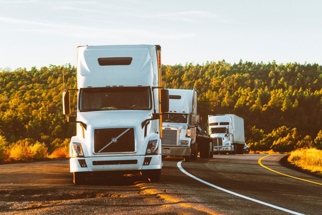 three trucks parked on the side of the road